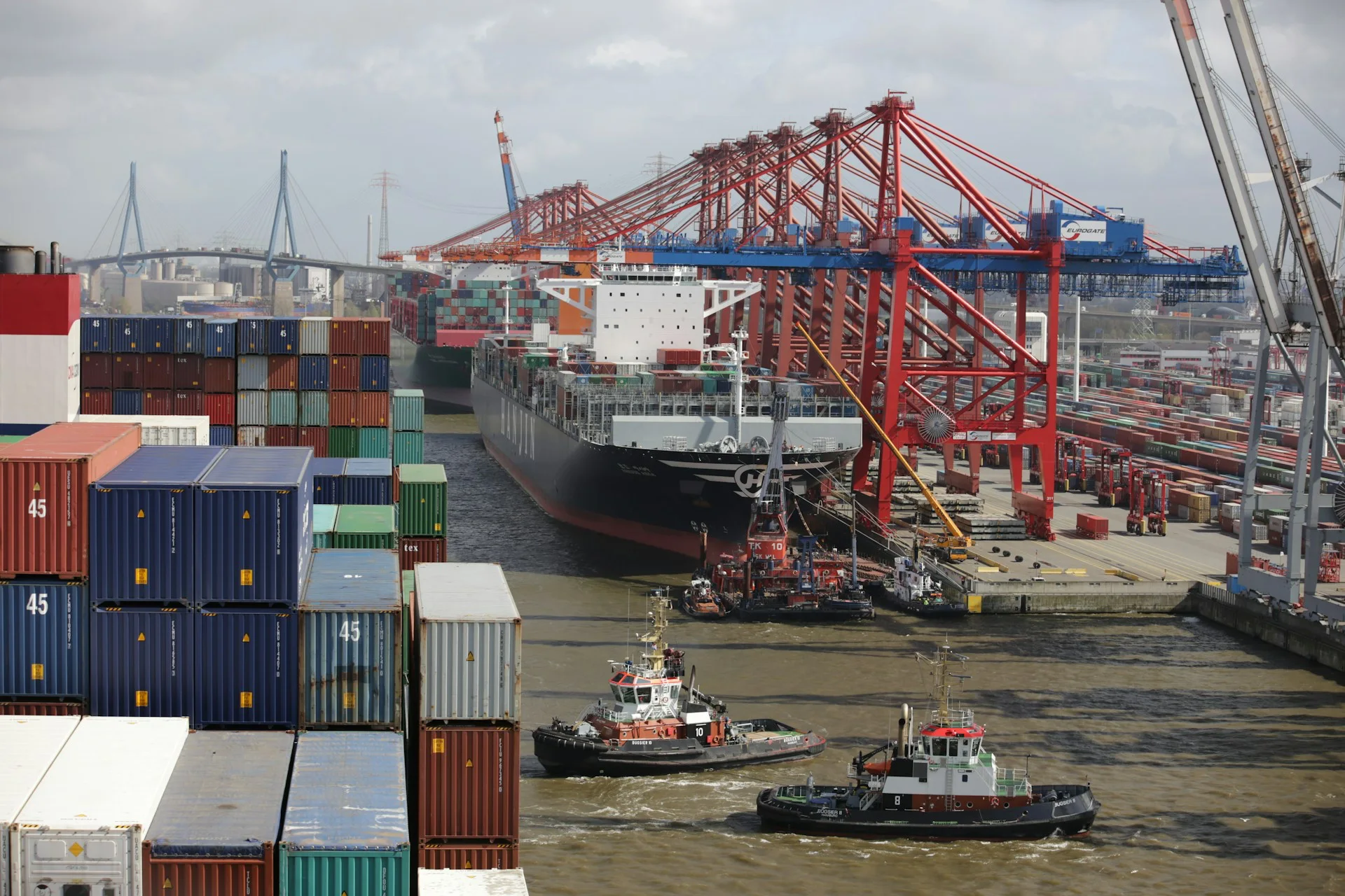 A bustling port in Tijuana with shipping containers and cranes, showcasing the city's logistics and manufacturing industry. Perfect for emphasizing premier recruitment services in Tijuana, attracting skilled professionals in logistics and manufacturing sectors.